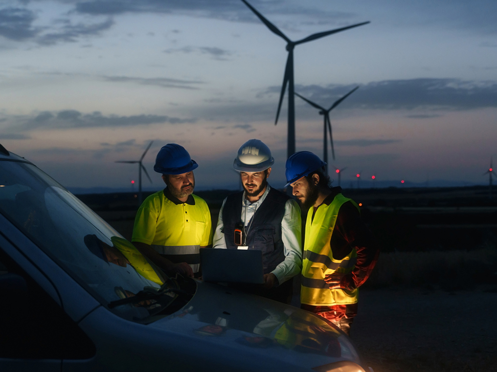 Technicians engineers working in wind turbine electricity plant at night