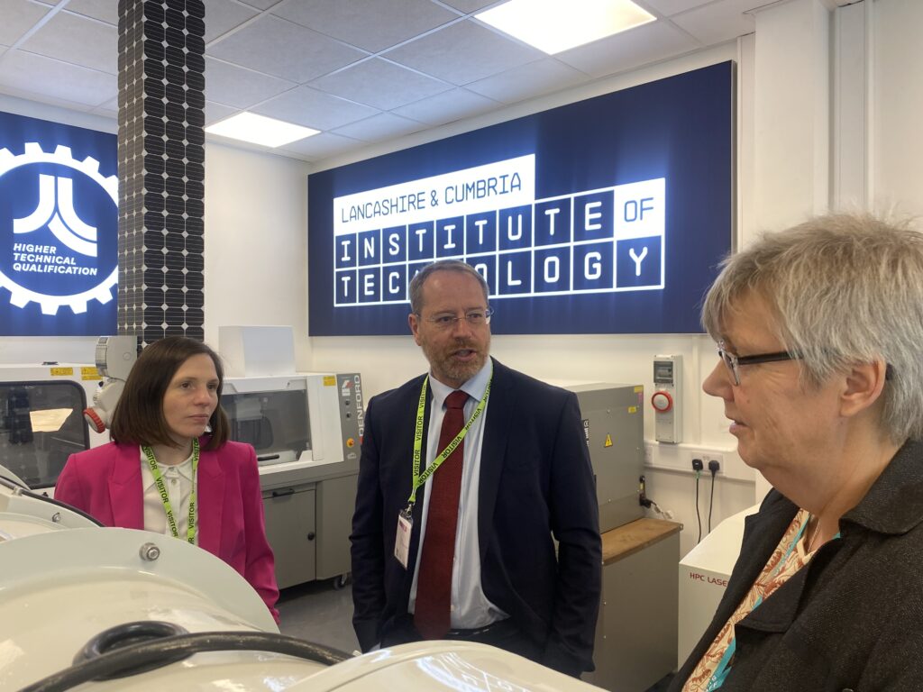two MP's stood infront of IoT sign with the University Dean