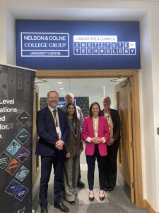 group of people smiling stood in a doorway under an Institute of Technology sign