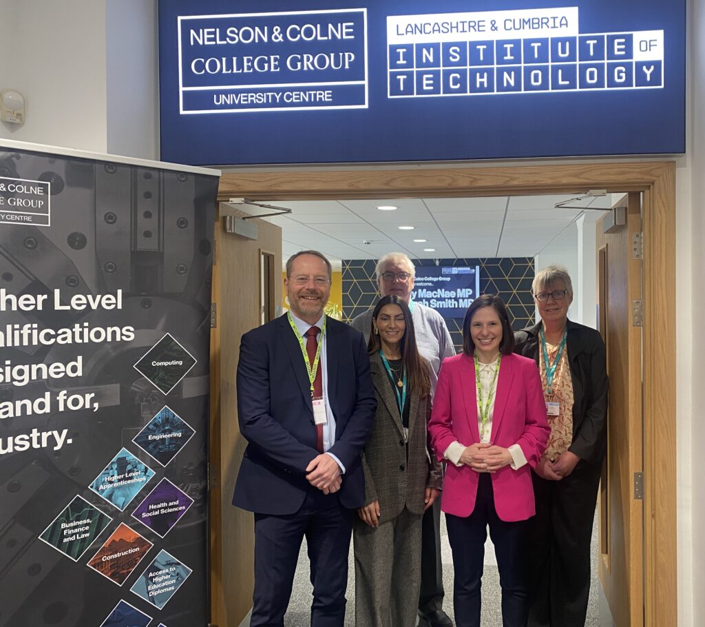 group of people smiling stood in a doorway under an Institute of Technology sign